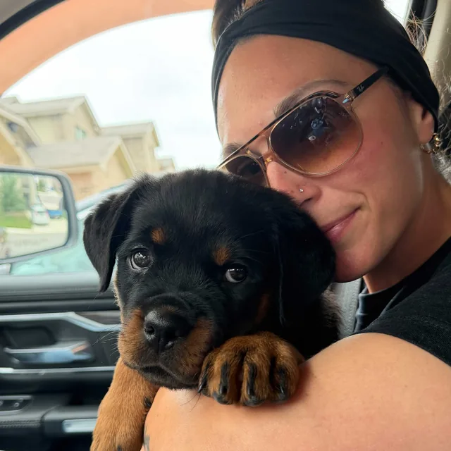 An owner with her Rottweiler puppy after training